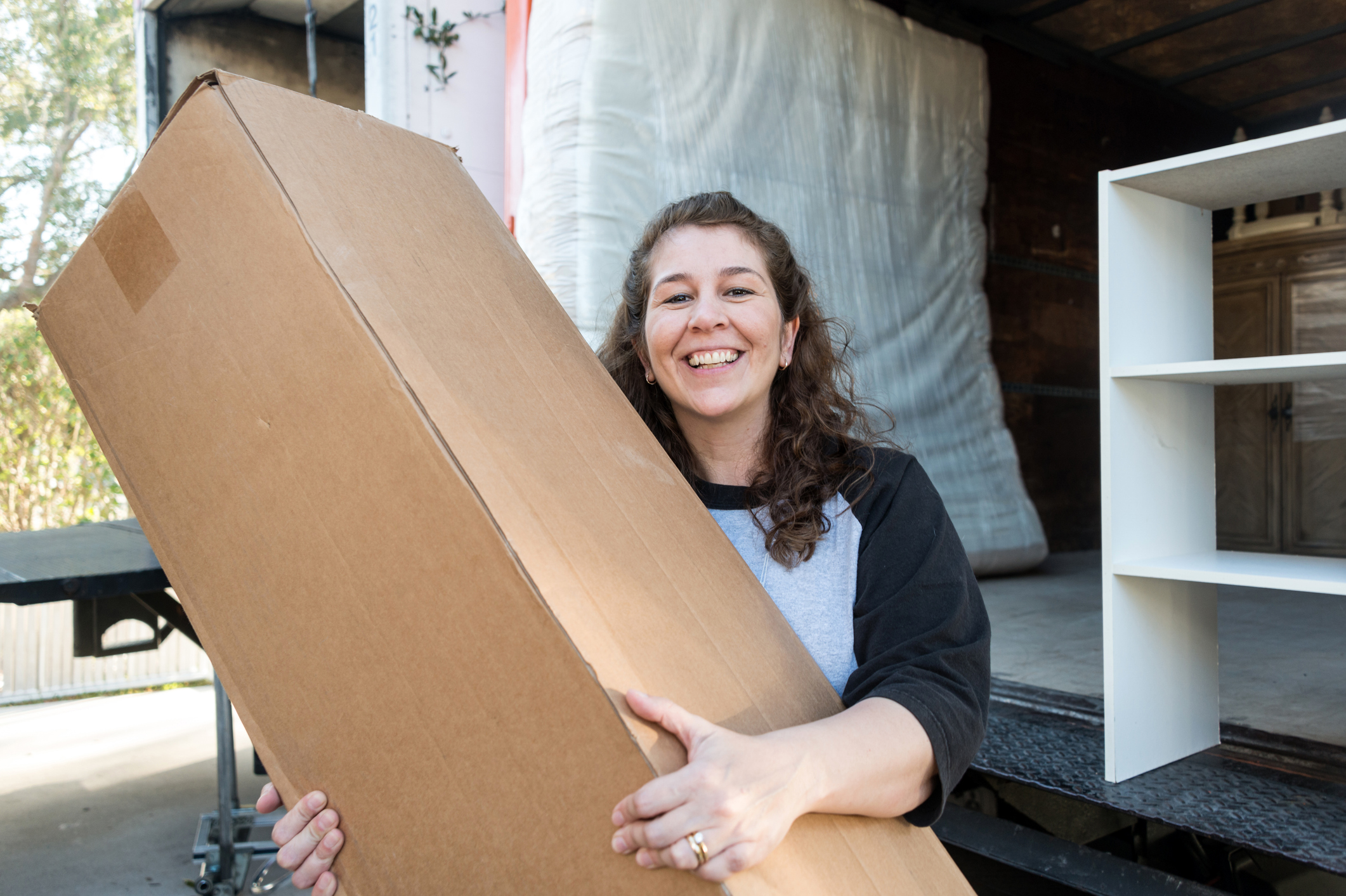A smiling woman holding a rectangular box